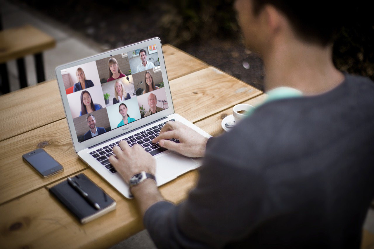 Professional man working on a laptop showing colleagues in an online meeting