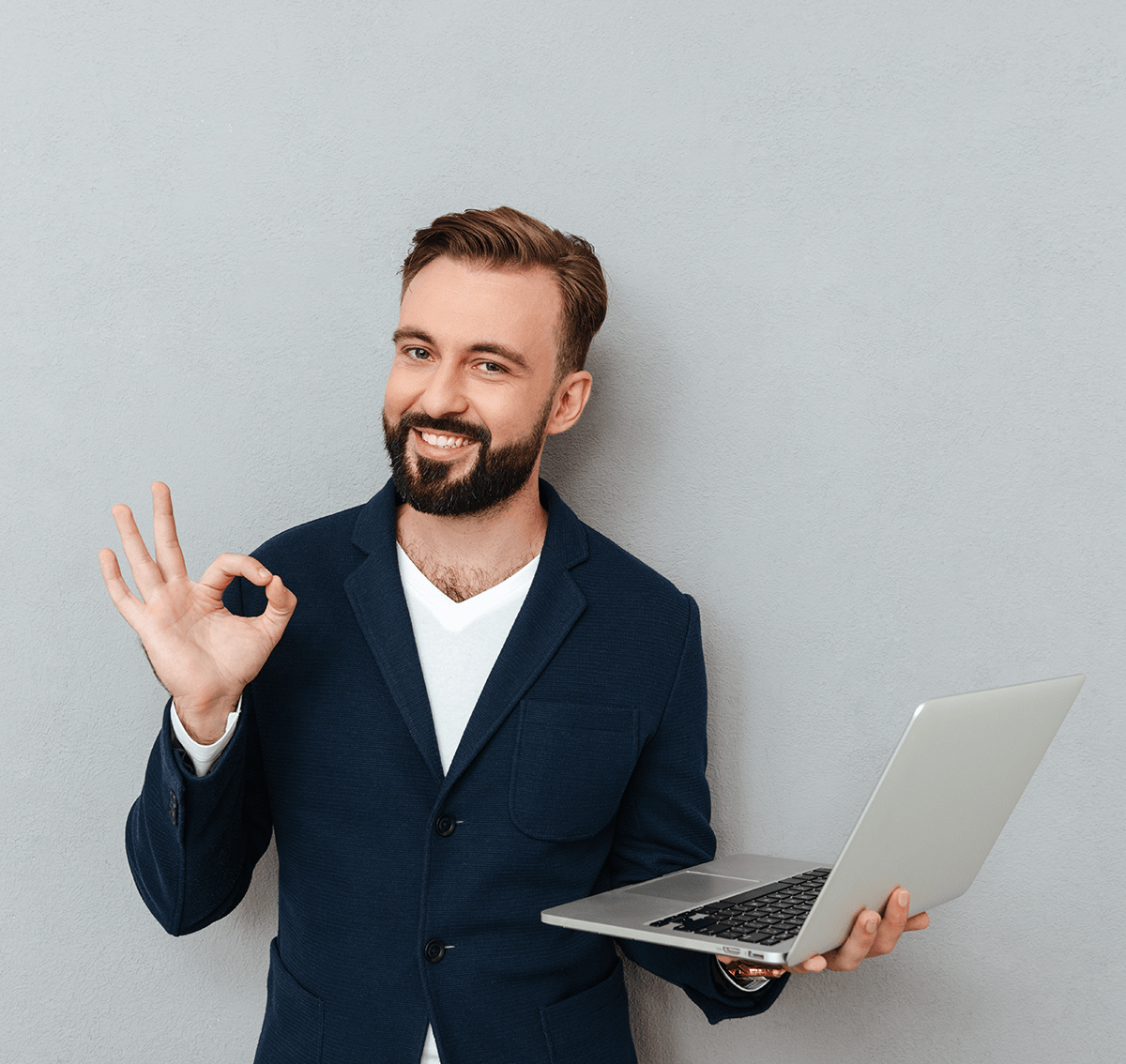 Smiling professional man giviing okay gesture and holding a laptop